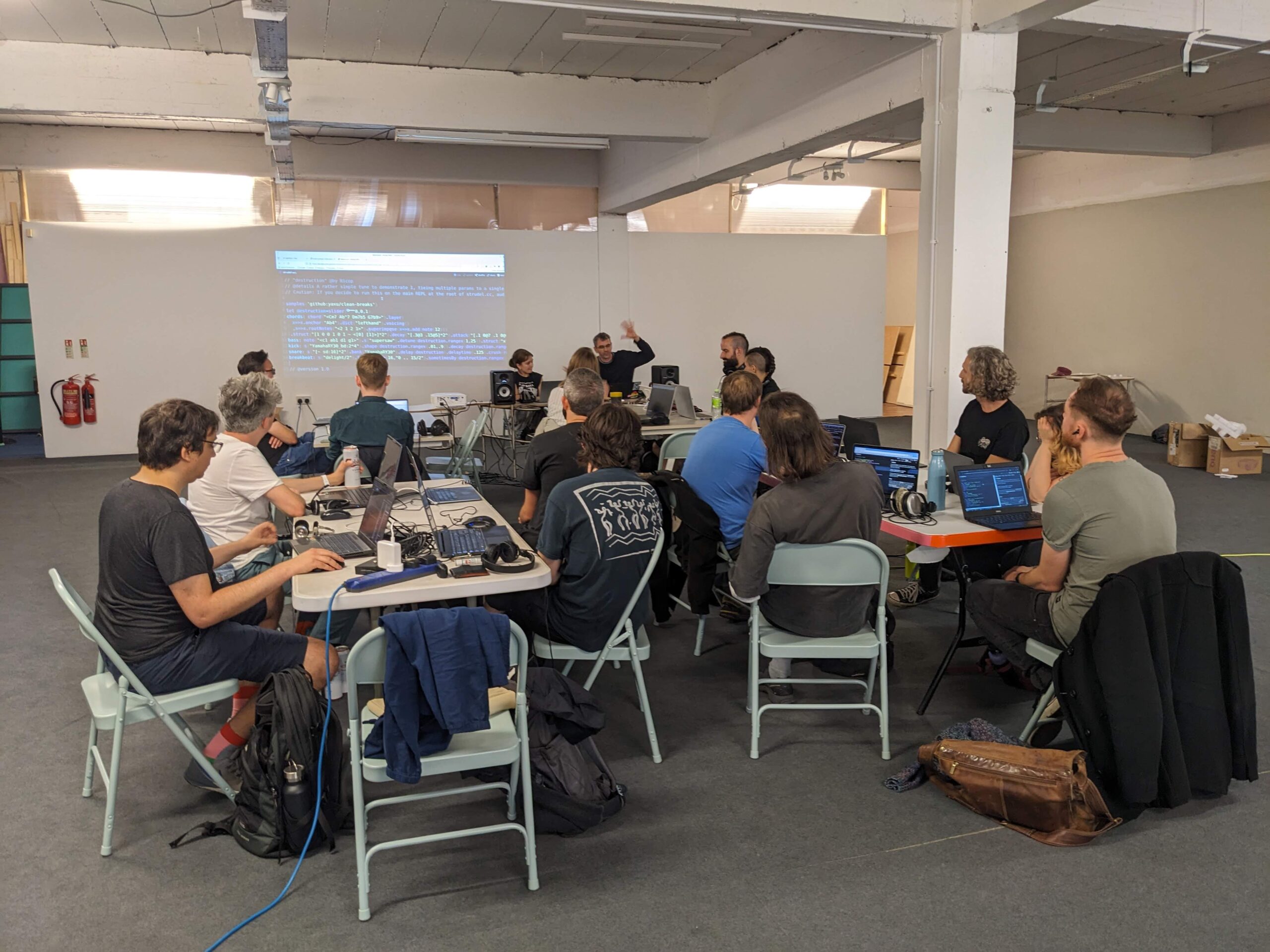 a group of people with laptops at a live coding event